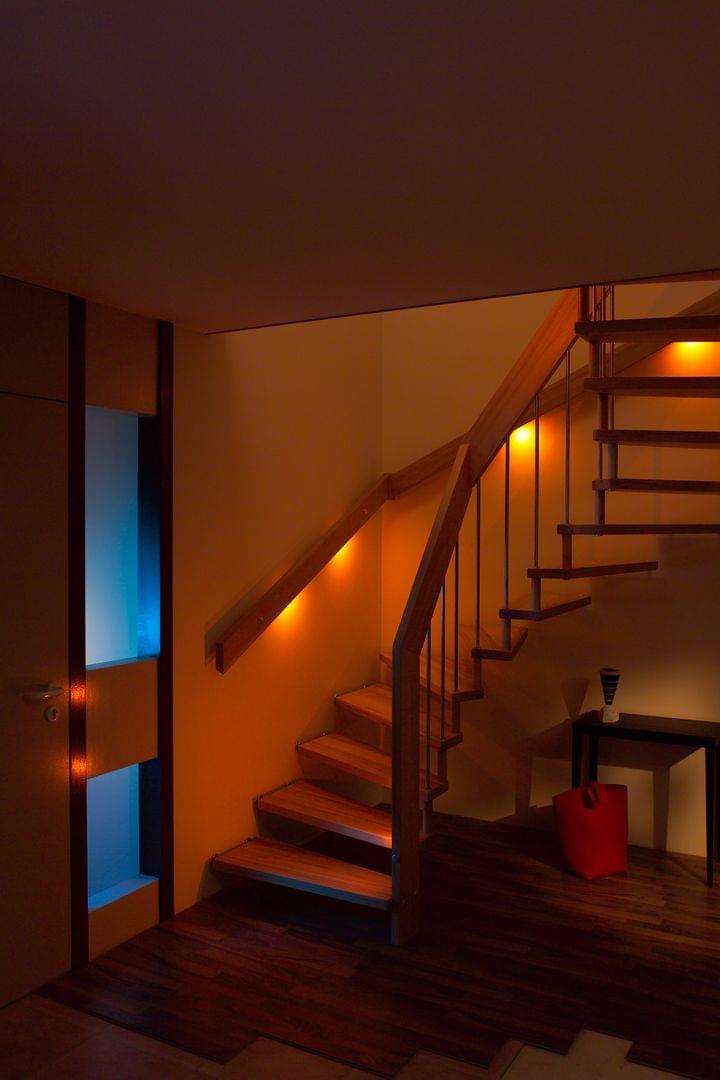 Holztreppe mit Treppenlicht im Wandhandlauf